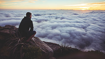 Photo: Man gazing out on cloudy horizon